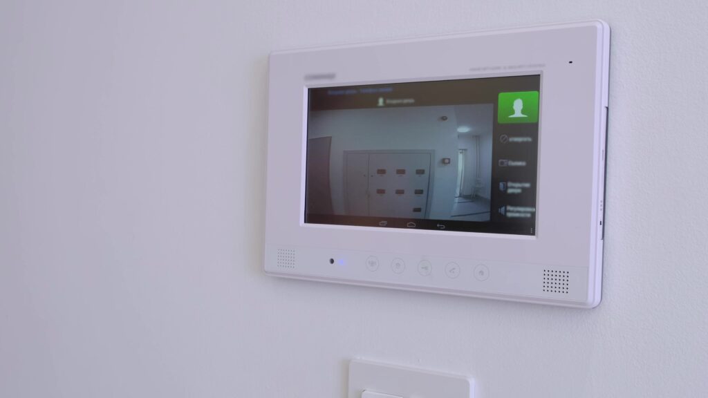 smart home, a man answers a call to the intercom, side view. Monitoring, unlock. Apartment video intercom system, video doorbell with camera and monitor.